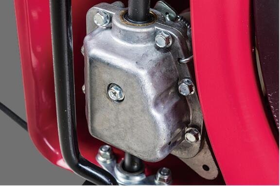2026/06/1002286585.jpg - pricemagicgh.com Close-up of a square metal housing with bolts, mounted to a red machine frame, with hoses nearby.