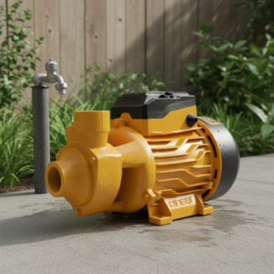 Orange industrial water pump on a concrete patio with a garden and a faucet in the background, ready for irrigation use.