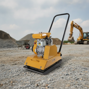 Yellow plate compactor on a gravel construction site with a backhoe in the background, ready for compaction work